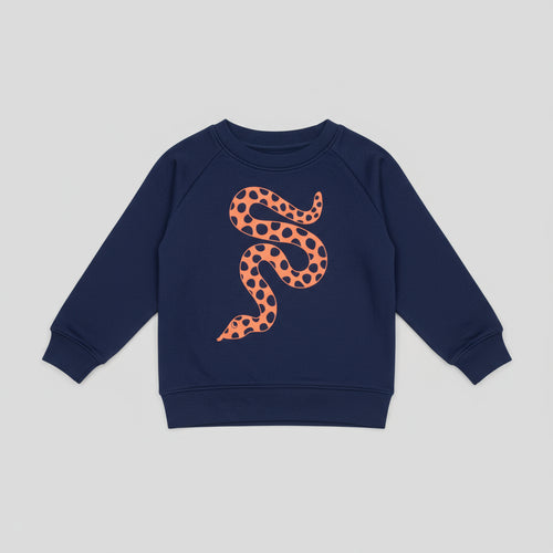 Navy blue sweatshirt with a orange snake design on a wooden surface